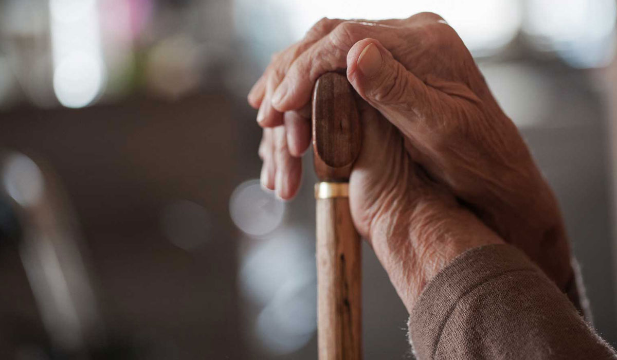 Elderly person with a walking stick