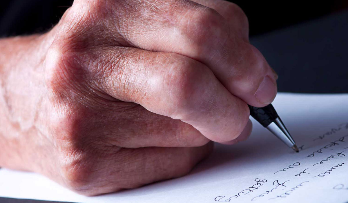Older person writing with a pen